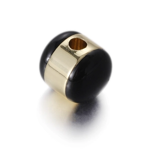 Macro detail of black enamel egg charm with a golden band for DIY jewelry making