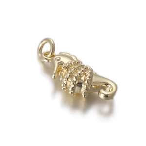 Detail of a golden seahorse charm with polished texture and jump ring for jewelry making