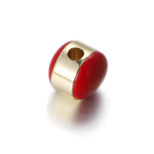 Macro detail of red enamel egg charm with a wide gold metallic band and central hole