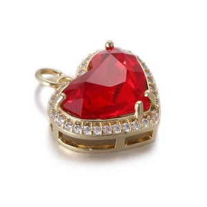 Primer plano detallado de un colgante de corazón rojo con engaste de oro brillante