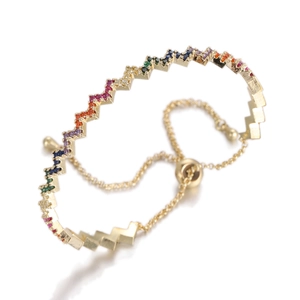 Detail of adjustable gold wave bracelet with colorful zircon stones and pull-ball clasp