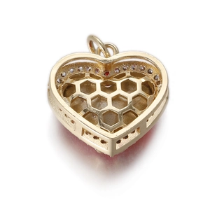 Detalle del colgante de corazón dorado con una estructura trasera hexagonal de panal