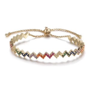 Macro detail of adjustable gold bracelet with zigzag pattern and rainbow zircon stones