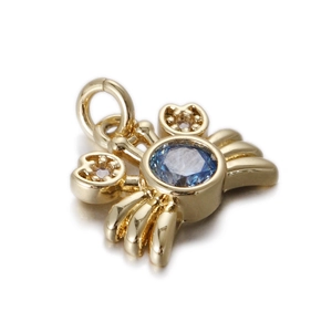 Macro view of a gold crab pendant with a blue center stone and white zircon accents