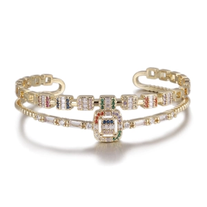 Close-up of gold layered open bangle with colorful rectangular zirconia and micro-pavé gems