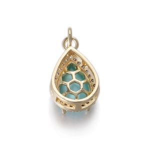 Detalle de colgante de gota dorado con piedra azul claro y parte trasera calada