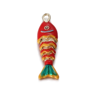 Dettaglio macro del ciondolo a forma di pesce rosso colorato con smalto rosso e verde