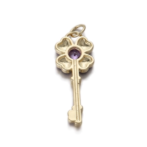 Detailed view of a gold clover key pendant with a central purple gemstone inlay
