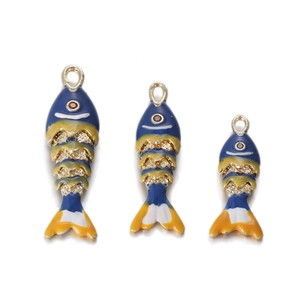 Dettaglio di tre ciondoli a forma di pesce rosso colorati per gioielli fai-da-te