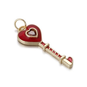 Detailed view of a gold-plated heart-shaped key pendant with red enamel and ruby