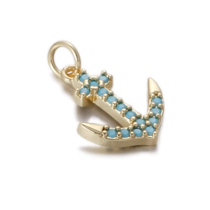 Detailed close-up of a golden anchor pendant with sky blue inlaid stones and polished ring