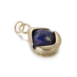 Close-up of a drop-shaped gold pendant with faceted blue lapis lazuli gemstone