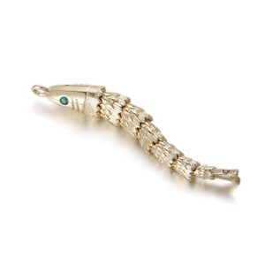 Detailed macro of articulated gold koi fish pendant with green gemstone eyes and scales