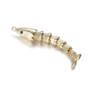 Macro detail of golden fish pendant featuring flexible segments and green zircon eyes