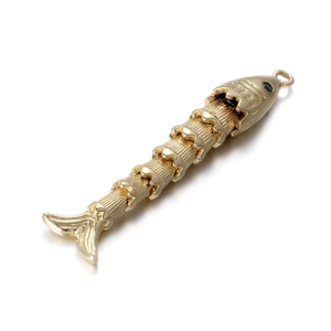 Detailed view of the 14k gold-plated articulated koi fish pendant with green enamel eyes