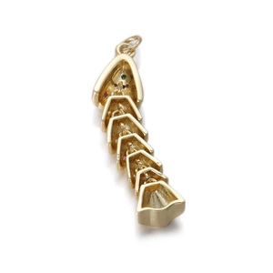 Macro detail of 14k gold plated fishbone pendant charm for jewelry making