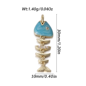 Close-up of 14k gold fish pendant with blue enamel and crystal details showing dimensions