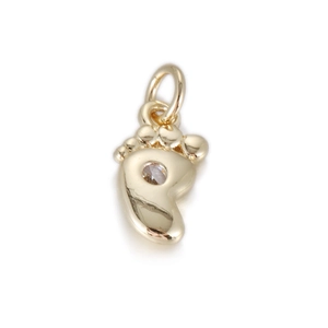 Detailed close-up of a 14k gold baby footprint pendant with a clear round-cut gemstone