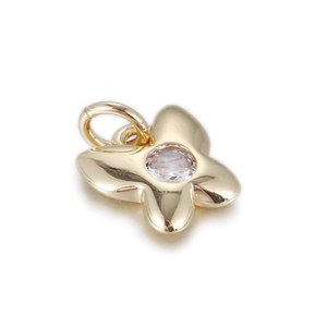 Macro detail of a 14k gold plated flower pendant with a clear round cubic zirconia stone