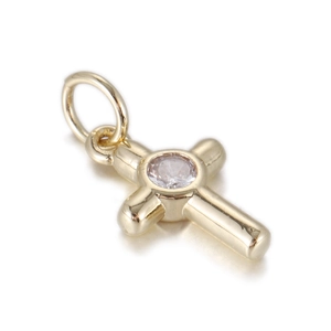 Macro shot of 14k gold cross pendant with central sparkling zircon stone inlay