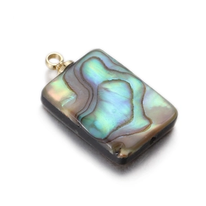 Macro view of rectangular abalone shell pendant with vibrant iridescent colors and gold ring