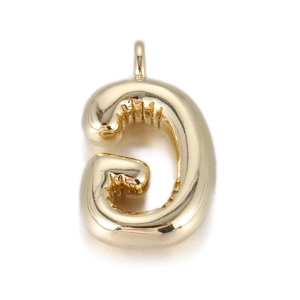 Macro view of a 3D balloon-style gold letter G pendant with polished reflective surface
