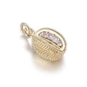 Macro detail of a 14k gold shell pendant with four sparkling white zircon stones