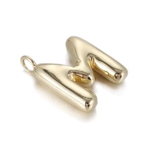 Macro shot of gold balloon-style letter M pendant with 3D polished mirror finish