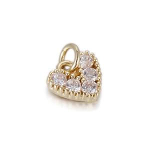 Macro detail of a 14k gold plated heart pendant with sparkling cubic zirconia inlay