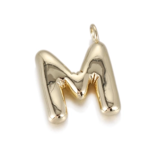Detailed view of a shiny gold letter M pendant with a polished balloon style finish