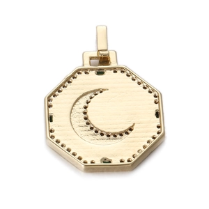 Detail of octagonal gold pendant featuring a crescent moon and brushed metal texture