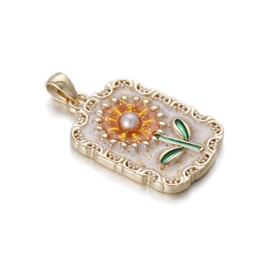 Macro shot of rectangular floral tarot pendant with faux pearl and gold-plated details