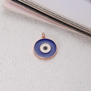 Macro detail of Bohemian evil eye tarot pendant with polished rose gold enamel finish