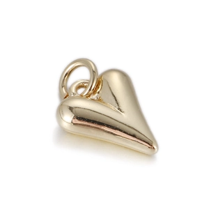 Detailopname van een gepolijste gouden hartvormige hanger met een metalen spiegelglans