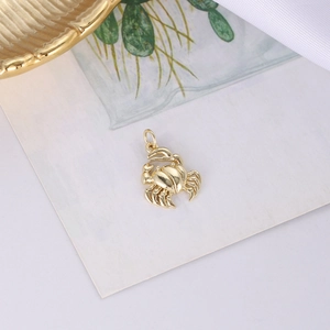 Nahaufnahme eines goldenen Krabbenanhängers mit rotem Herz für DIY-Schmuckherstellung