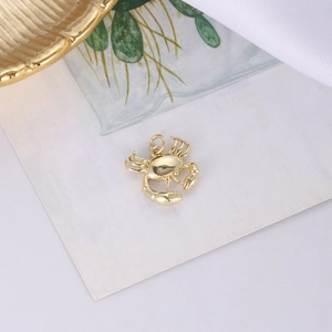 Makro-Detail eines polierten Gold-Krabbenanhängers mit rotem Herz für DIY-Schmuckdesign