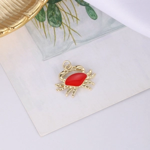 Makroaufnahme von vergoldetem Krabbenanhänger mit roter Emaille für DIY-Schmuckdesign