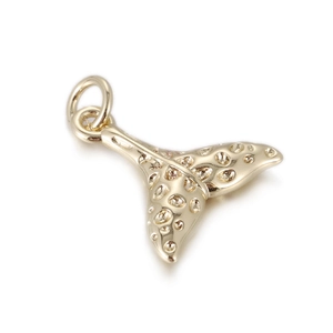 Detailed macro of a polished gold whale tail pendant with bubble textured finish and ring
