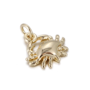 Detailed view of a polished gold crab charm with jump ring for jewelry making DIY