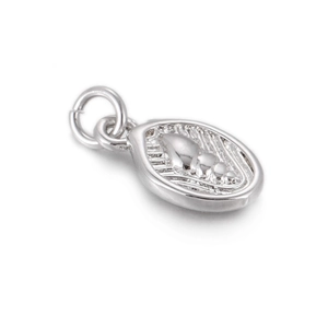 Macro shot of silver metal oval shell charm with detailed relief for DIY jewelry