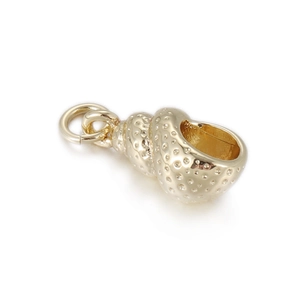 Detailed macro view of golden metal conch shell pendant charm with dotted texture