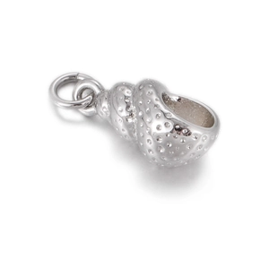 Macro detail of silver seashell charm with textured beads and polished metal finish