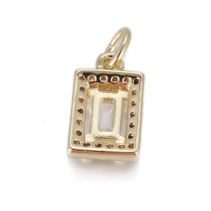 Macro shot of rectangular gold charm back view showing detailed setting and finish