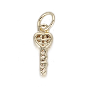 Detailed macro of golden heart-shaped key pendant with brown gemstone and metal ring