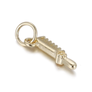Detail shot of a polished gold-plated mini key pendant with embossed star and metal ring