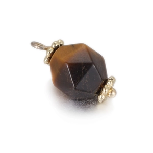 Macro detail of geometric faceted tiger eye stone pendant with golden metal accents