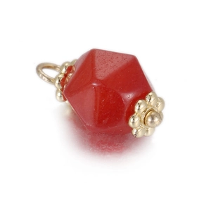 Macro detail of geometric red stone pendant with golden flower caps and bail
