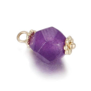 Macro shot of faceted purple gemstone pendant with gold floral metal caps and ring