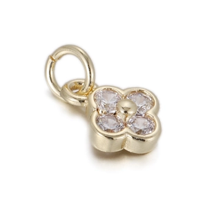 Macro shot of gold-plated clover pendant with four clear sparkling cubic zirconia stones