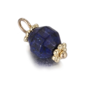 Macro shot of faceted blue lapis lazuli pendant with gold bead cap and sturdy ring